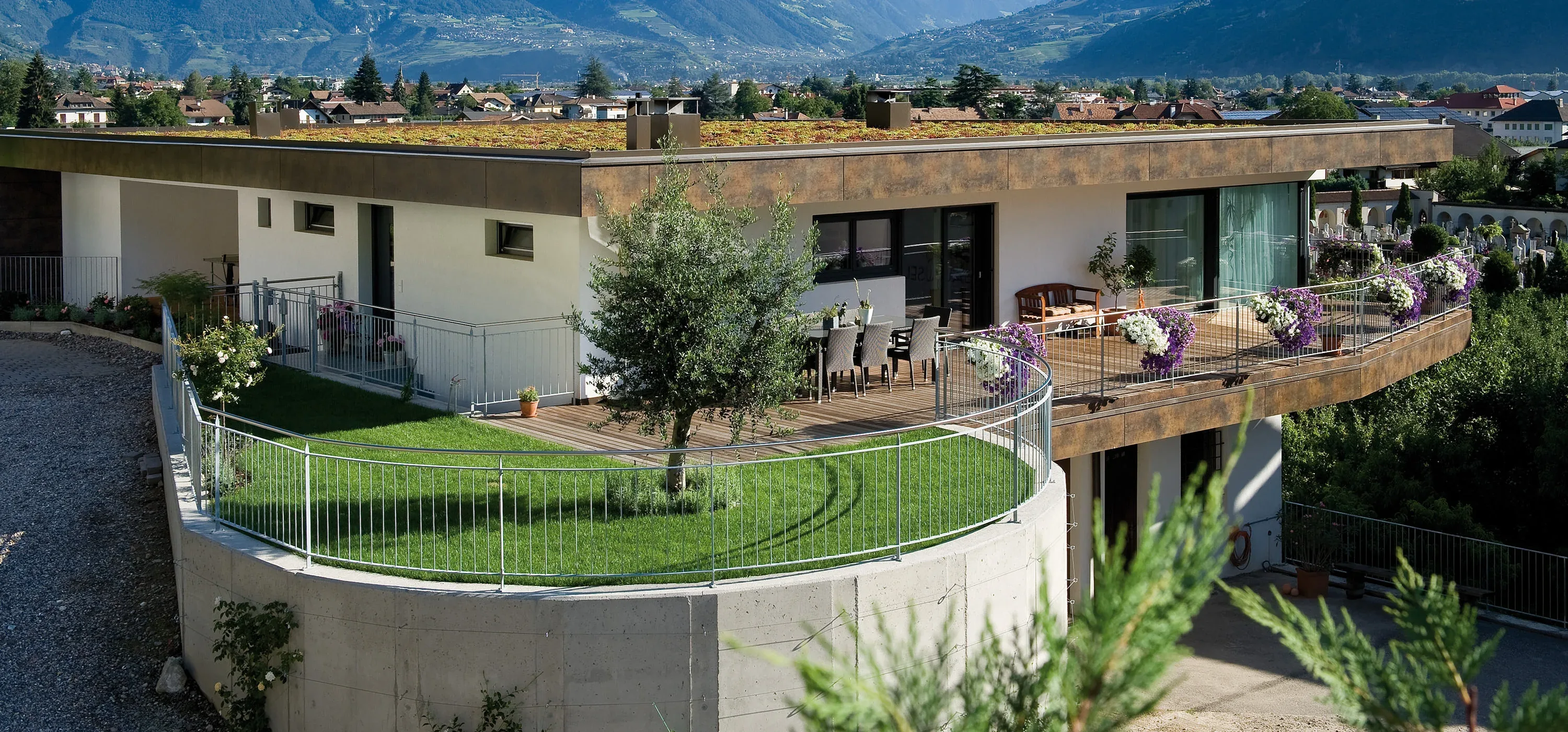 Begrüntes Flachdach über einer Wohnanlage mit Holzterrasse und Talblick