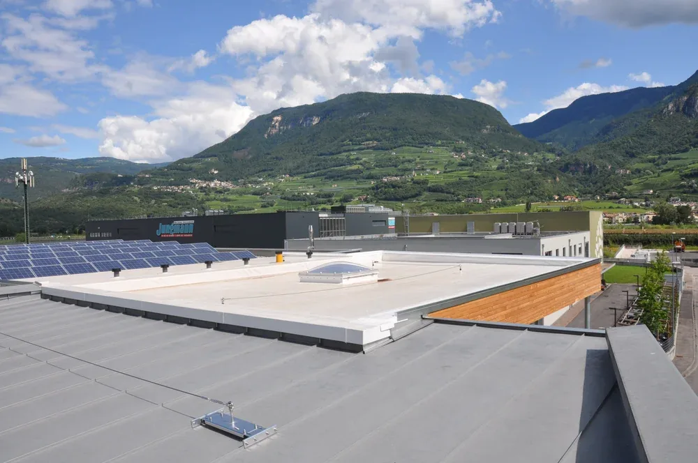 Sicherungssystem auf dem Flachdach eines Gewerbebaus, dahinter Photovoltaikmodule