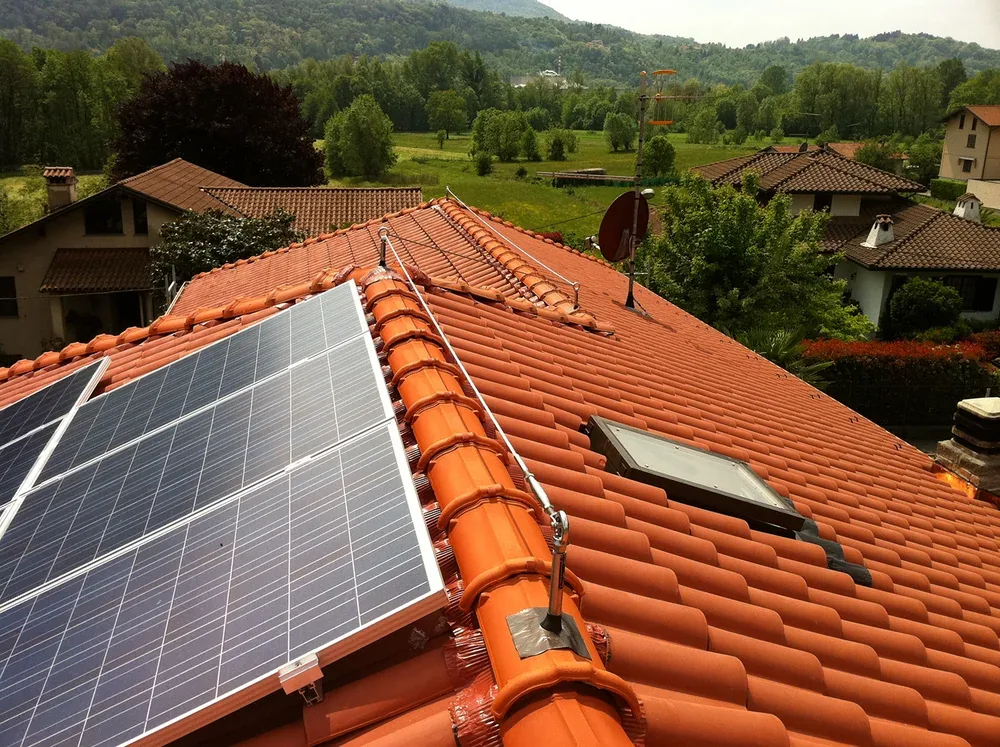 Photovoltaikmodule auf einem Ziegeldach, daneben ein gespanntes Sicherungsseil
