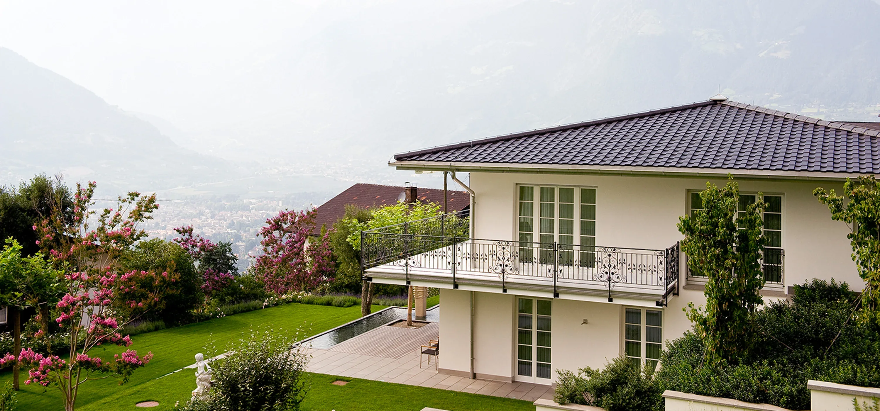 Walmdach und schmiedeeiserner Balkon einer Villa über dem Talkessel