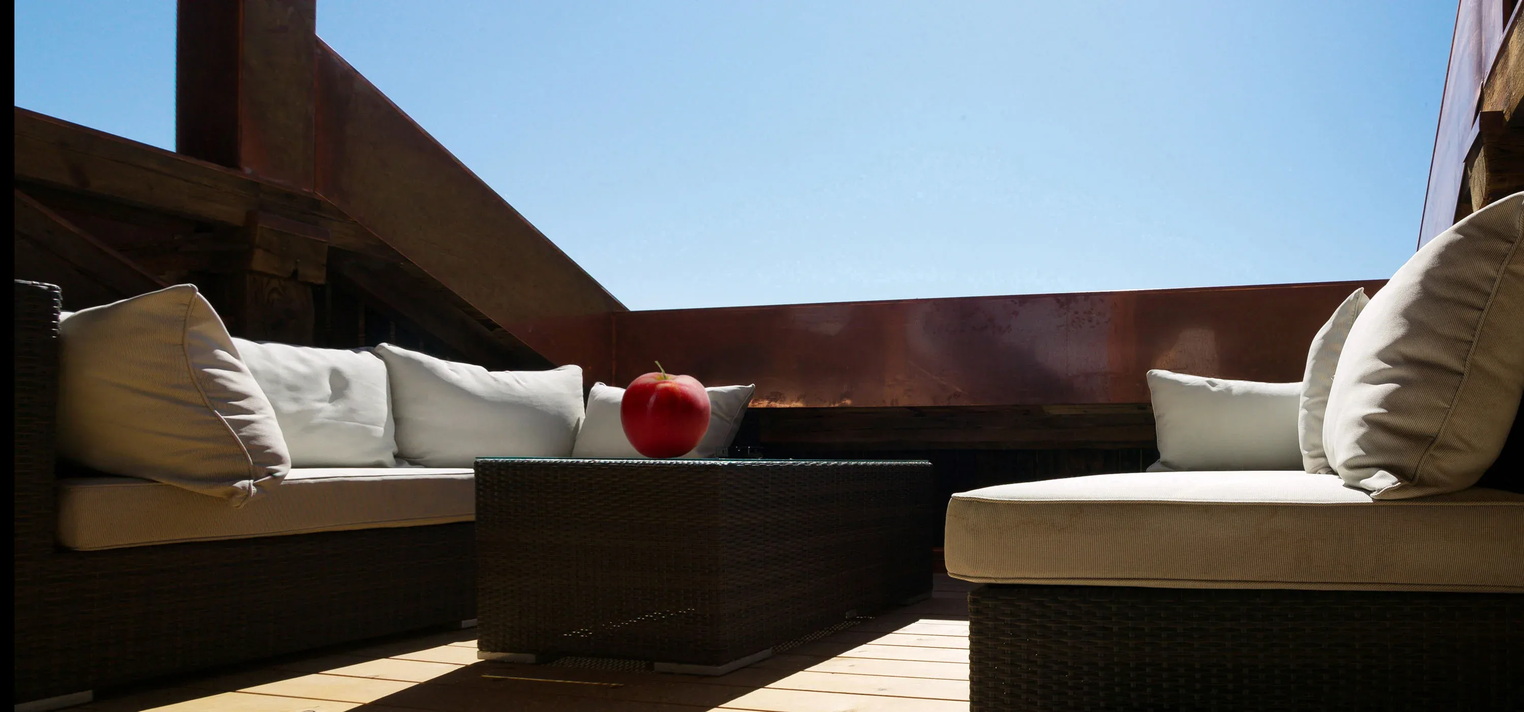 Loungemöbel auf einer Dachterrasse hinter einer Brüstung aus Kupferblech