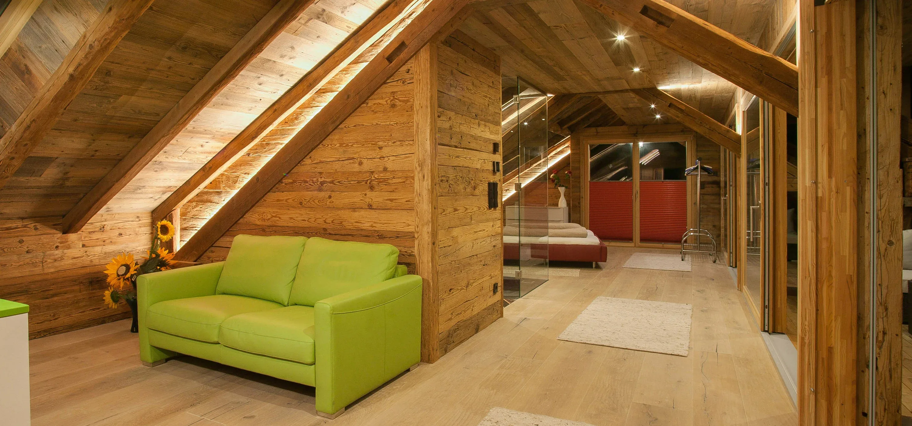 Dachgeschoss mit Altholzdecke und Dielenboden, Sofa unter der Dachschräge
