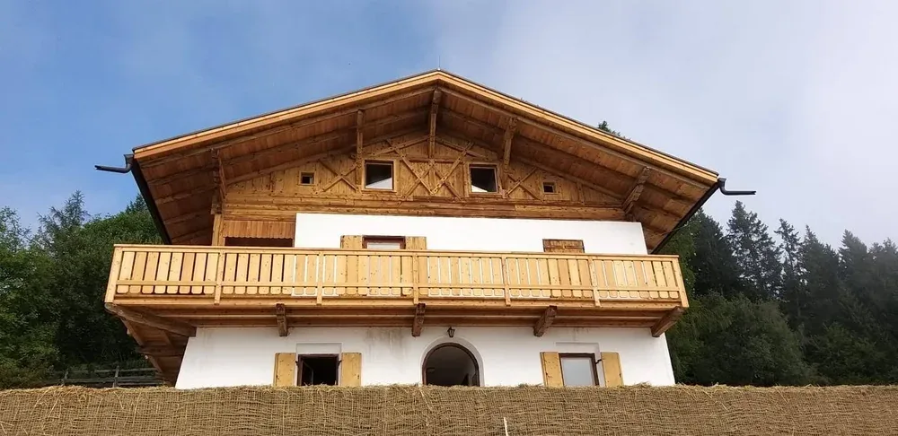 Bauernhaus nach der Sanierung mit neuem Holzgiebel und neuem Balkon