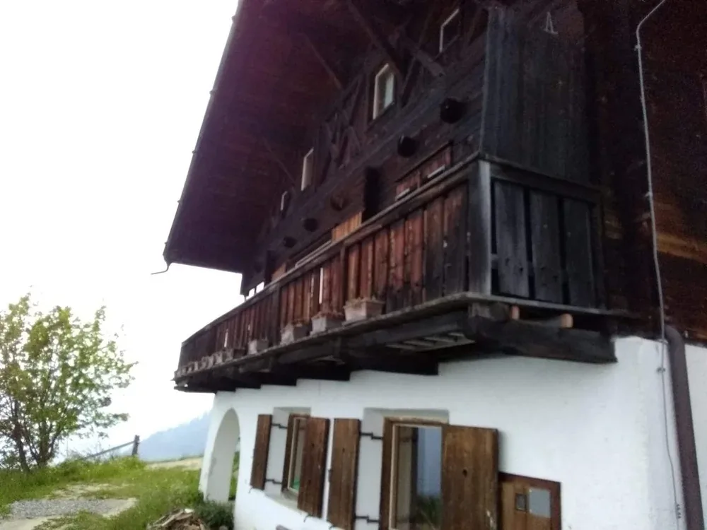 Vergrauter Balkon und Giebel des Altbestands, von unten gesehen