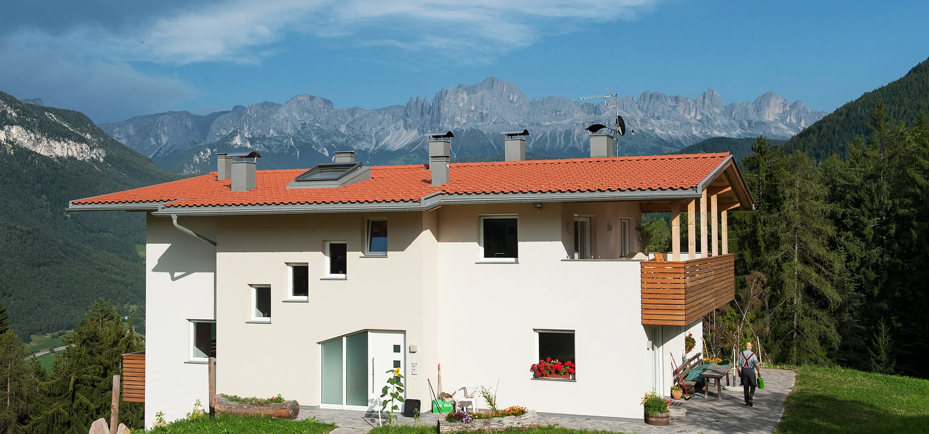 Wohnhaus mit neu gedecktem Ziegeldach, dahinter die Dolomiten
